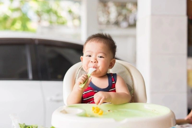 Giải đáp trẻ 14 tháng biết làm gì đó là bé đã biết cầm thìa xúc thức ăn